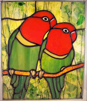 two lovebirds sitting on a branch in a leafy forest