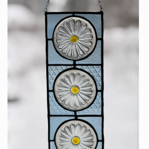 stained glass window panel featuring 3 clear daisies with pinnacle vodka glass background