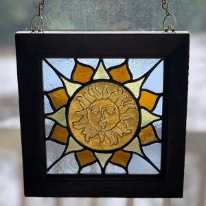 recycled glass stained glass panel featuring a sun with a face.