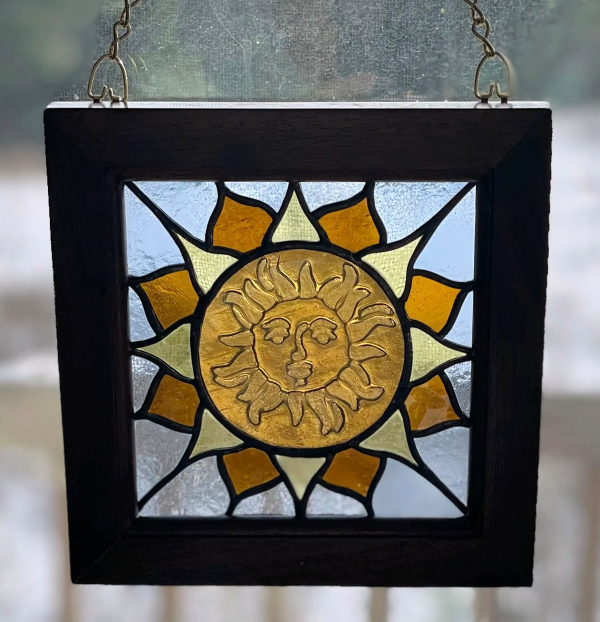 recycled glass stained glass panel featuring a sun with a face.